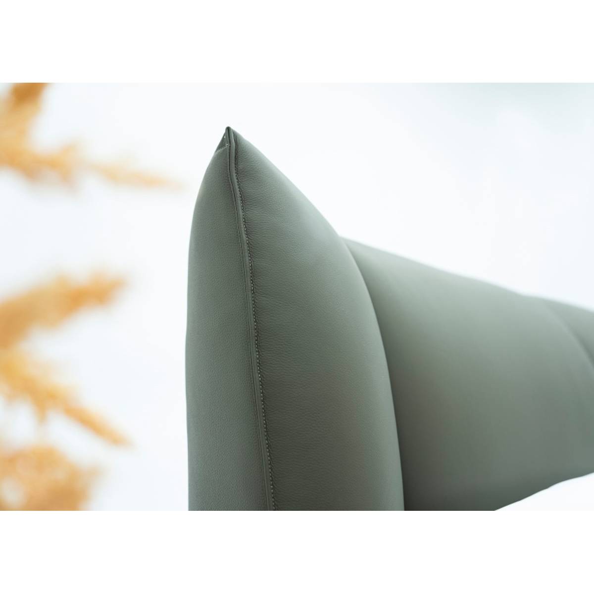 Close-up of the bed headboard corner showing leather texture and stitching