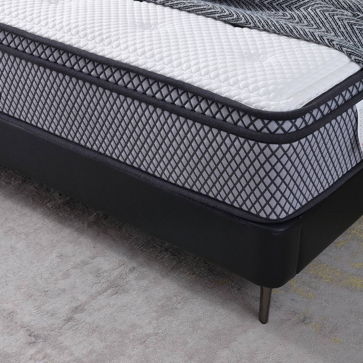 Side view of the bed frame showing the black leather base, metal legs, and mattress support structure
