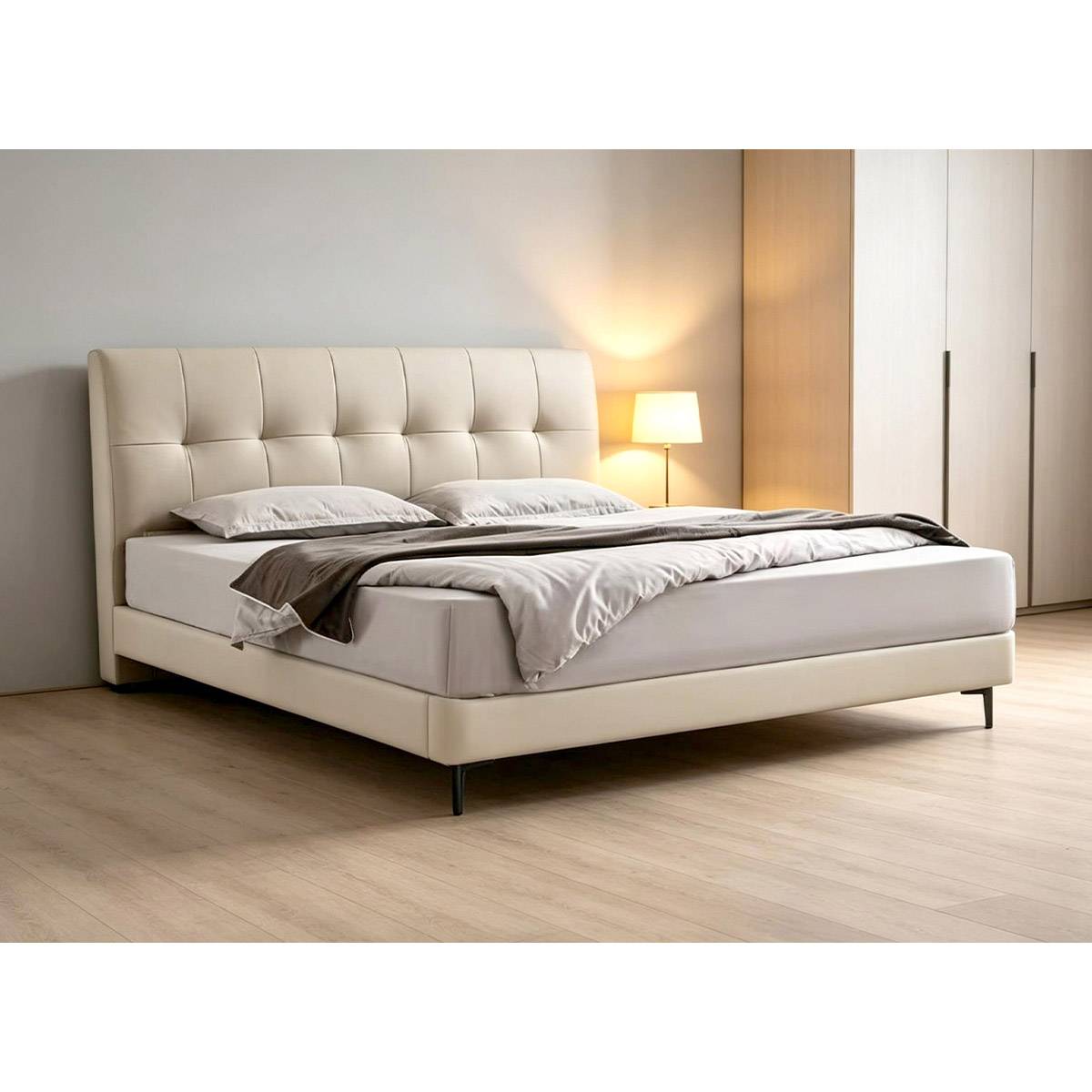 Beige tufted leather bed frame in a modern bedroom setting with wooden flooring