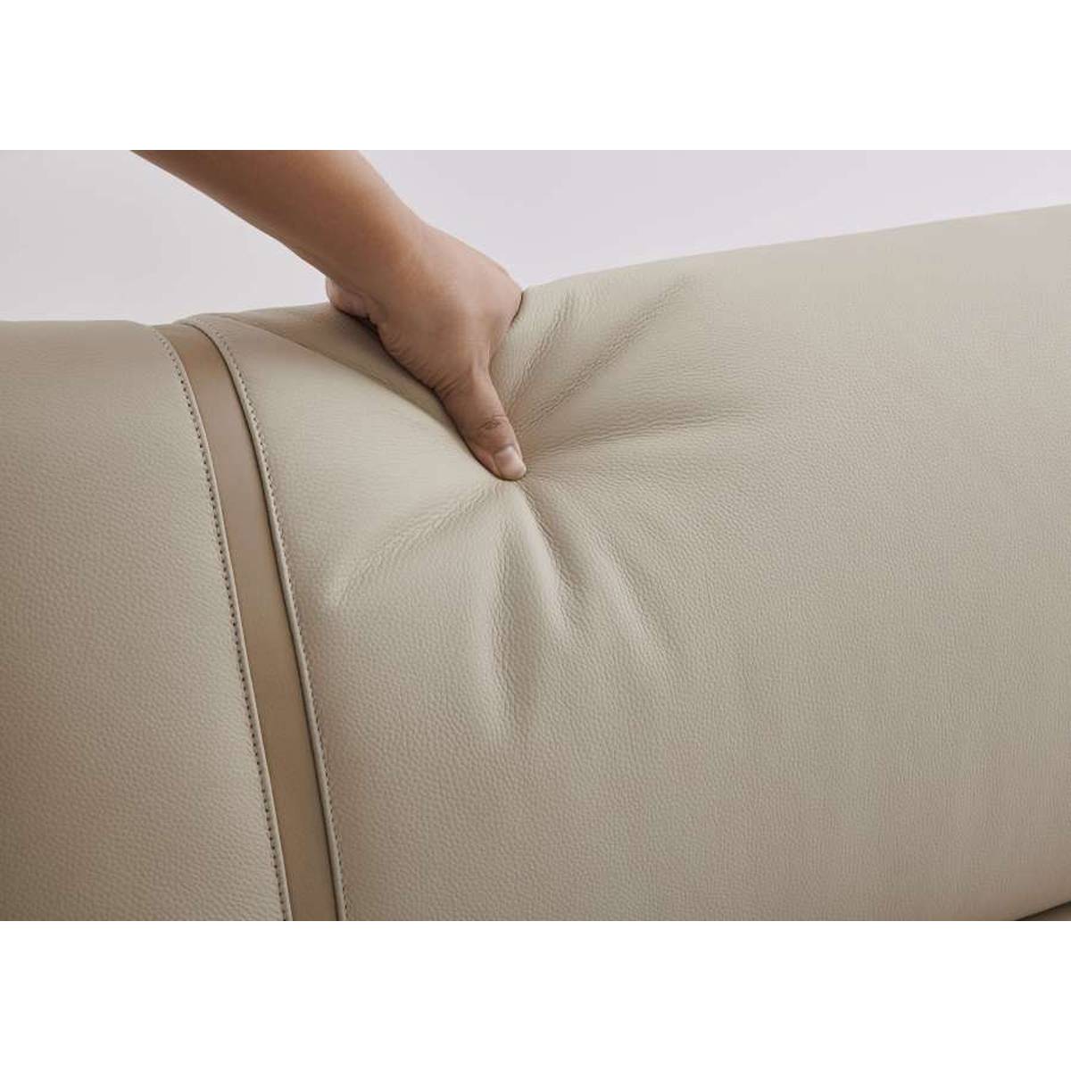 Hand pressing into the leather headboard to demonstrate softness and material quality