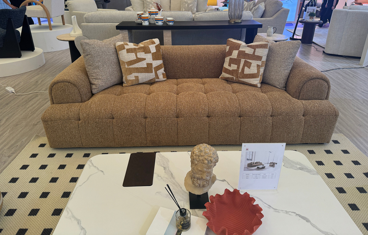 Full view of the brown fabric sofa in a showroom setting