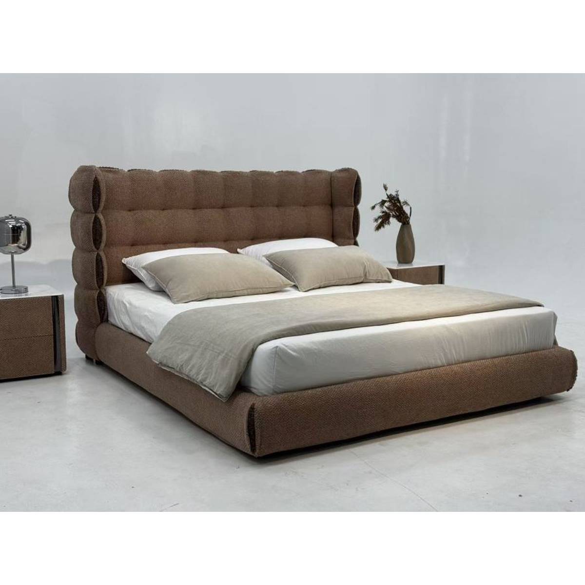Angled view of the modern upholstered bed showing the side profile and bedding arrangement