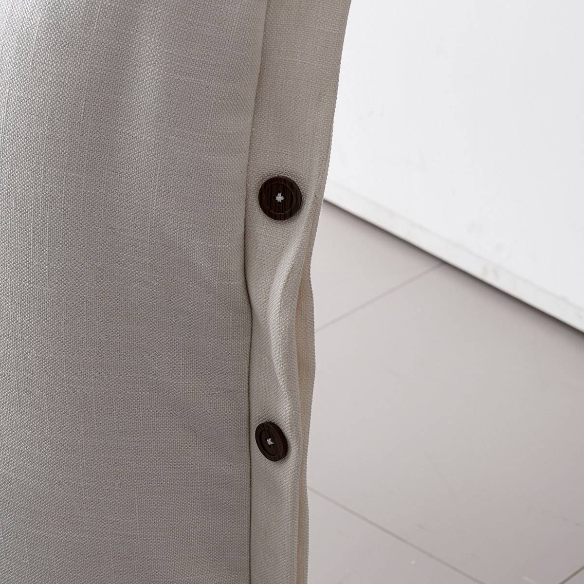 Close-up of the fabric texture and decorative buttons on the bed headboard
