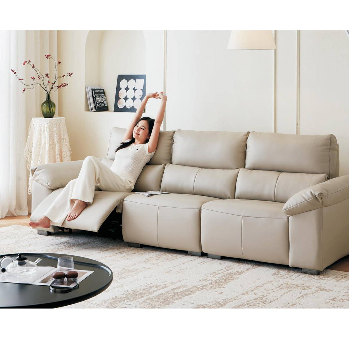 Front view of the beige leather sofa showing the reclining mechanism extended on the left side.