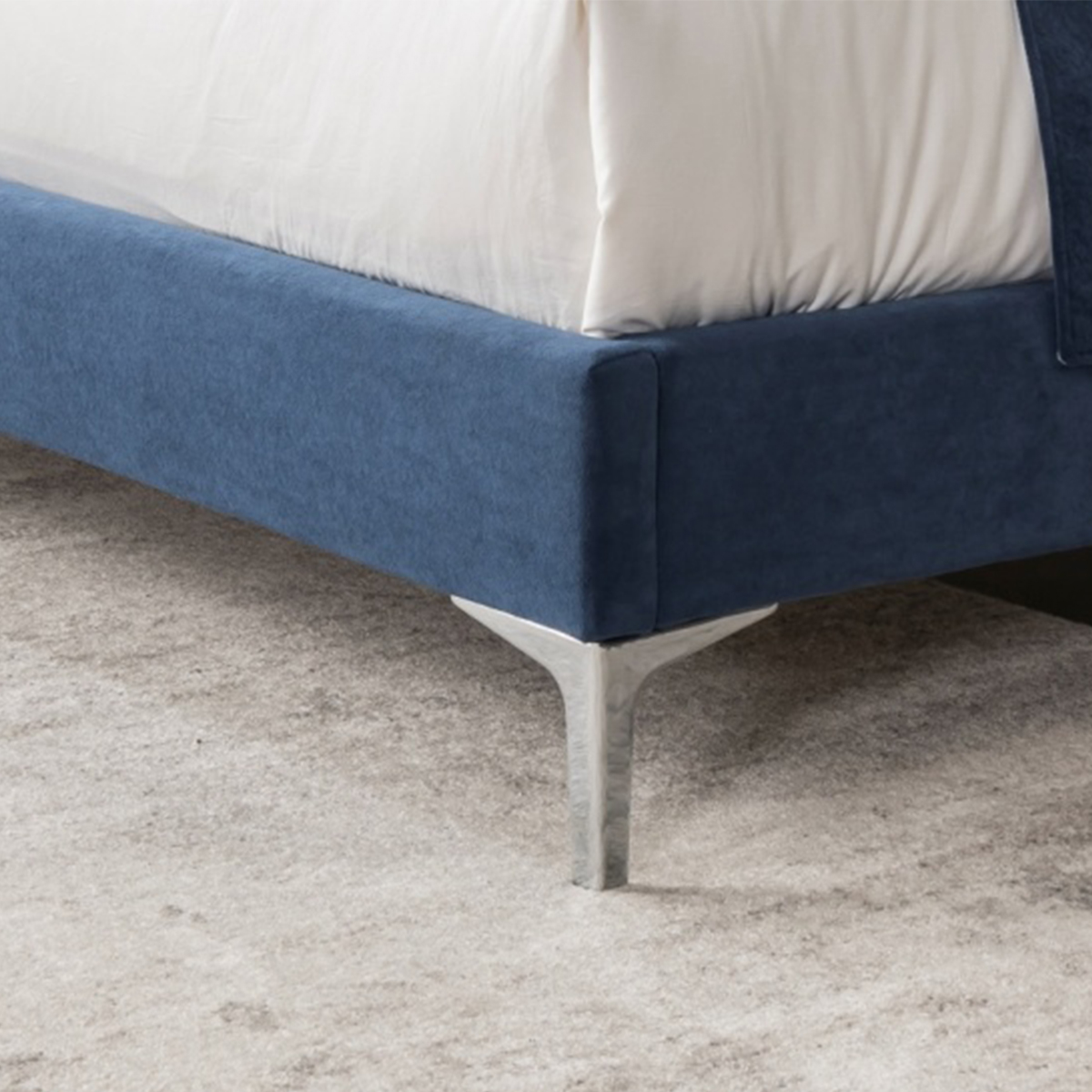 Close-up detail of the metal leg and blue velvet base corner