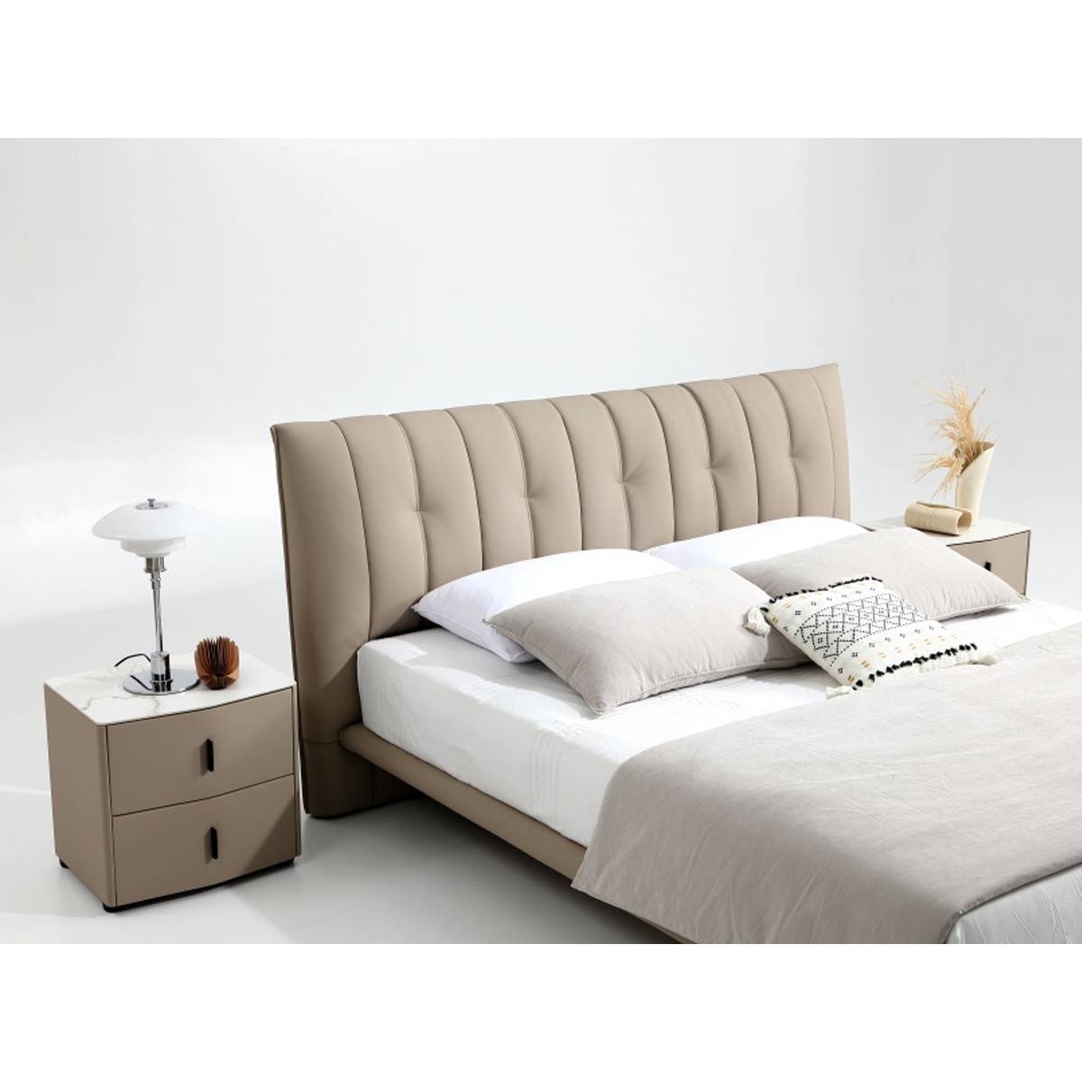 Full view of the beige tufted leather bed with matching bedside tables and white bedding
