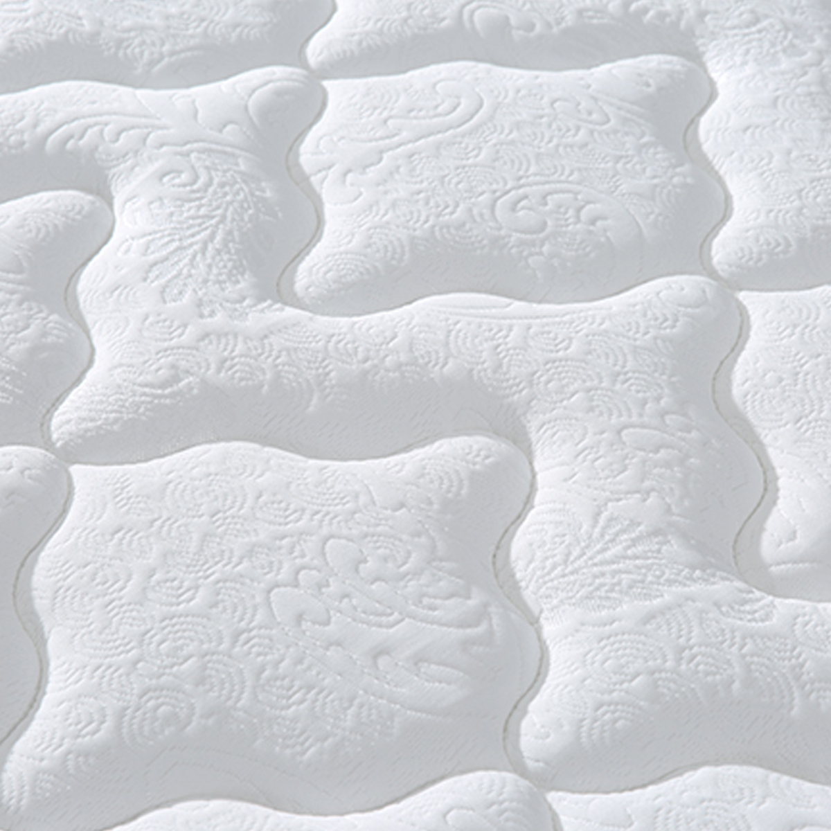 Close-up of the mattress surface showing the embossed floral pattern on the cotton fabric