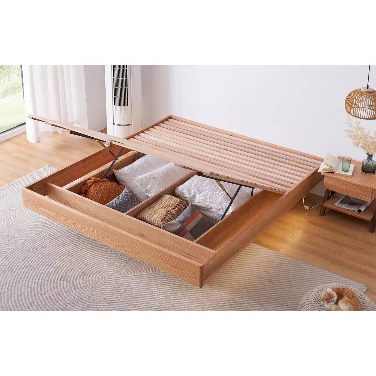 The bed frame with the slatted top lifted open to reveal storage space filled with pillows and bedding