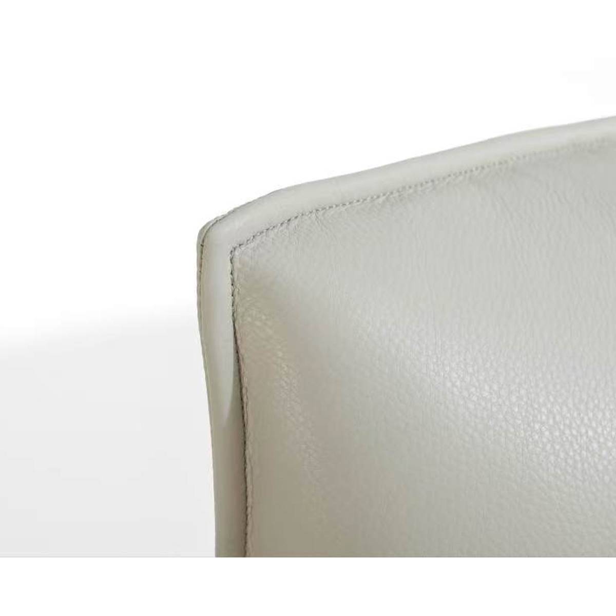 Close-up detail of the bed headboard corner showing stitching and leather grain