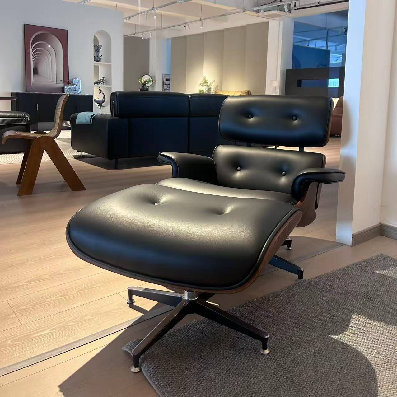 Side view of the lounge chair and ottoman in a showroom environment