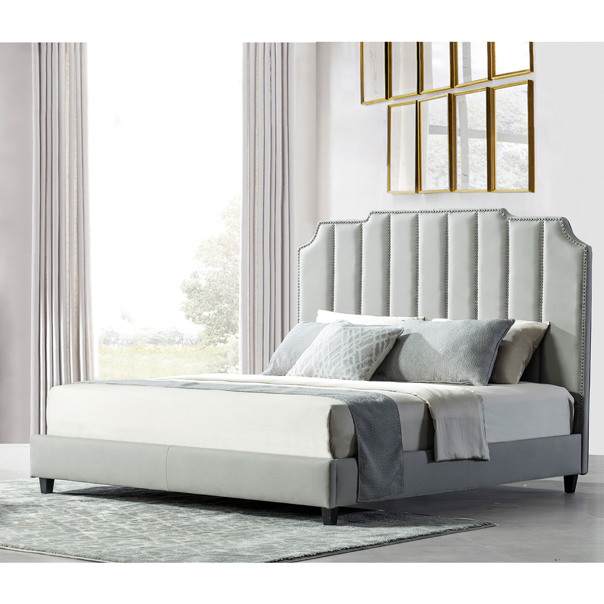 Grey upholstered bed with tufted headboard and nailhead trim