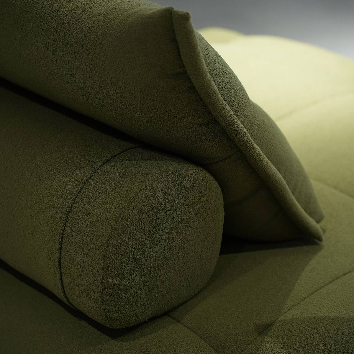 Close-up of the olive green fabric texture and pillow detail