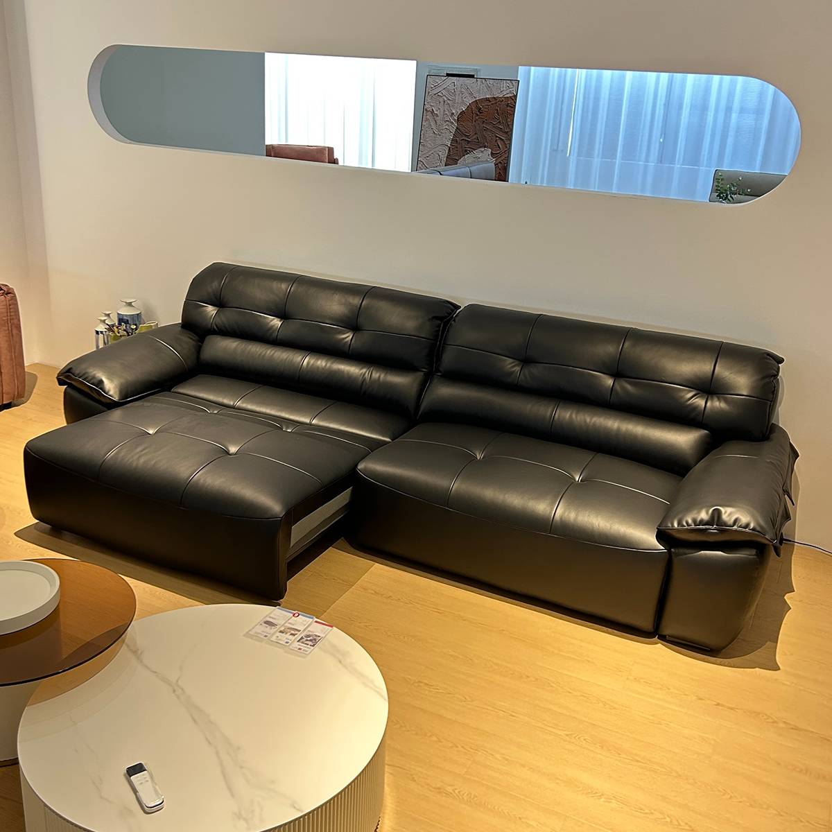 Black leather electric functional sofa in a modern living room setting