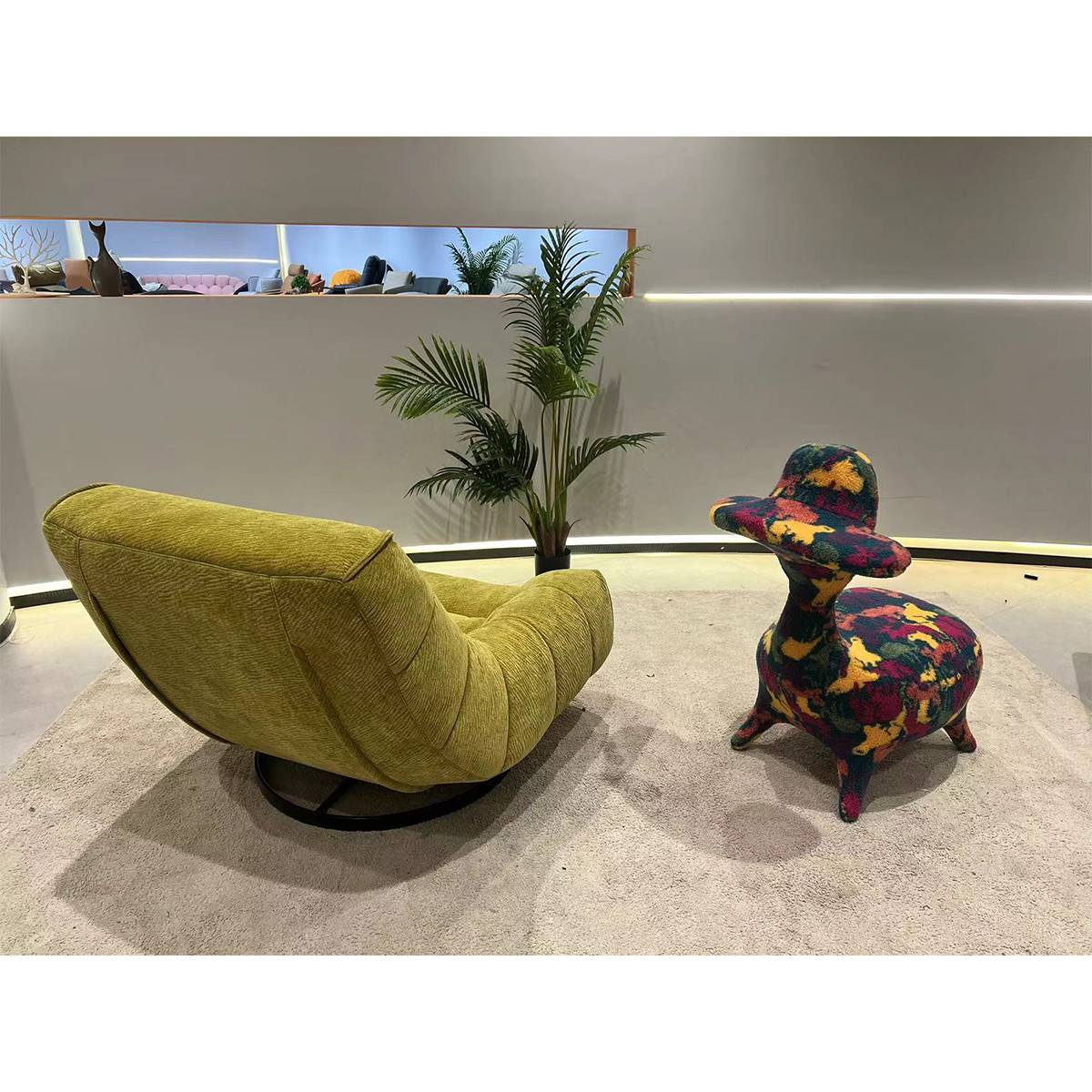 Green plush fabric swivel lounge chair back view showing swivel base