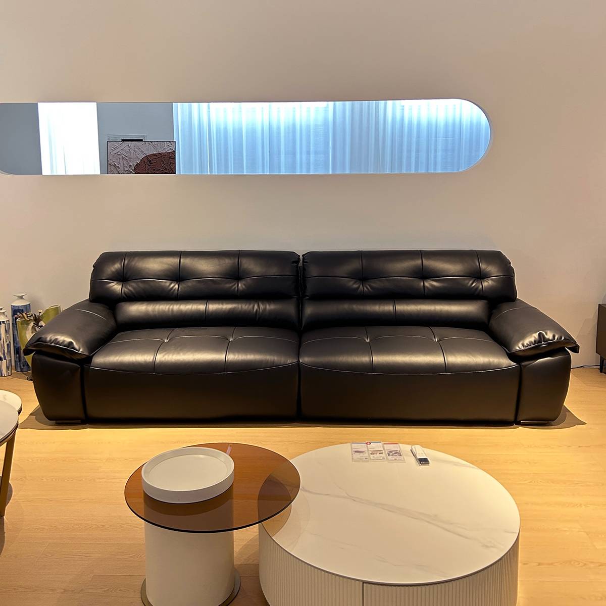 Angled view of the black sofa highlighting the armrest and reclining mechanism
