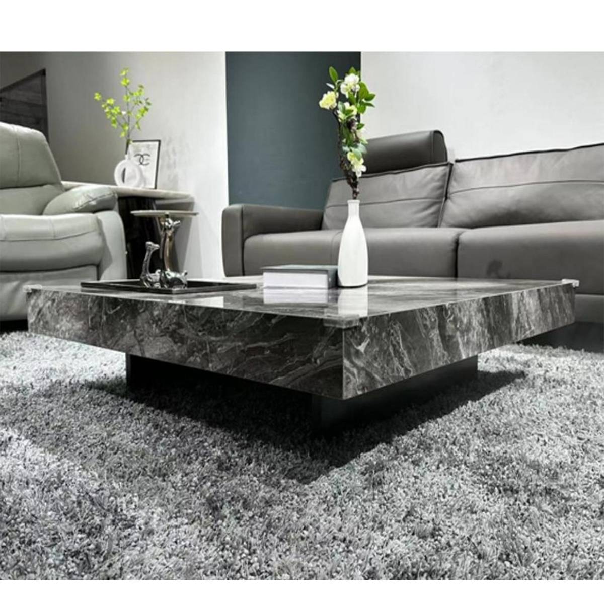 Dark grey marble-effect sintered stone coffee table with vase and books