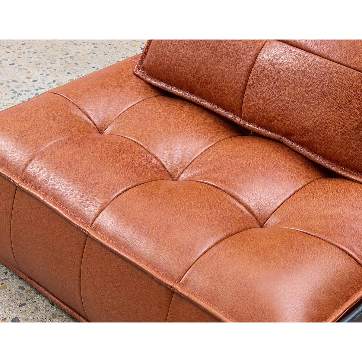 Close-up detail of the tufted leather texture on the brown sofa