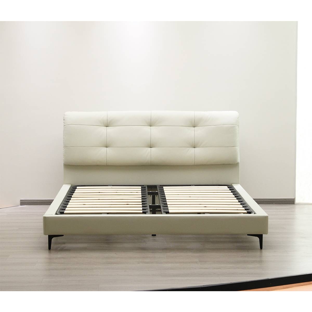 Bed frame without mattress showing wooden slat base