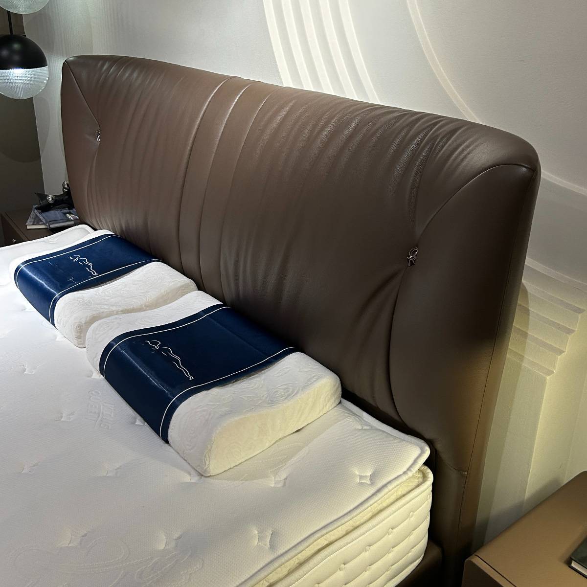 Close-up detail of the leather headboard texture and pillows