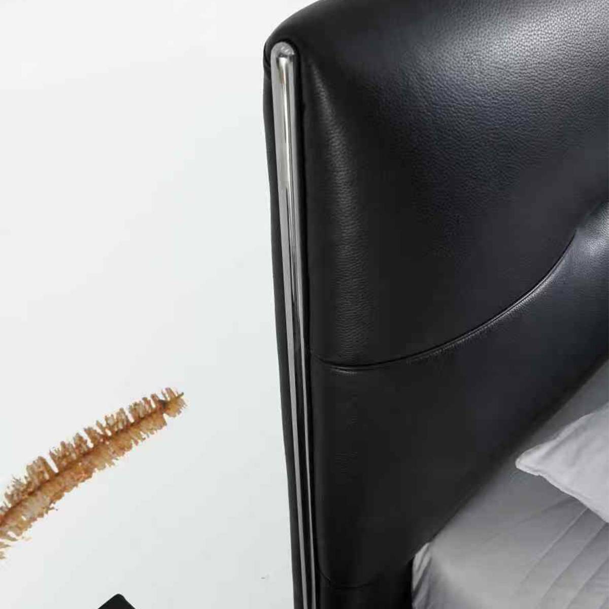 Close-up detail of the black leather headboard corner showing chrome trim