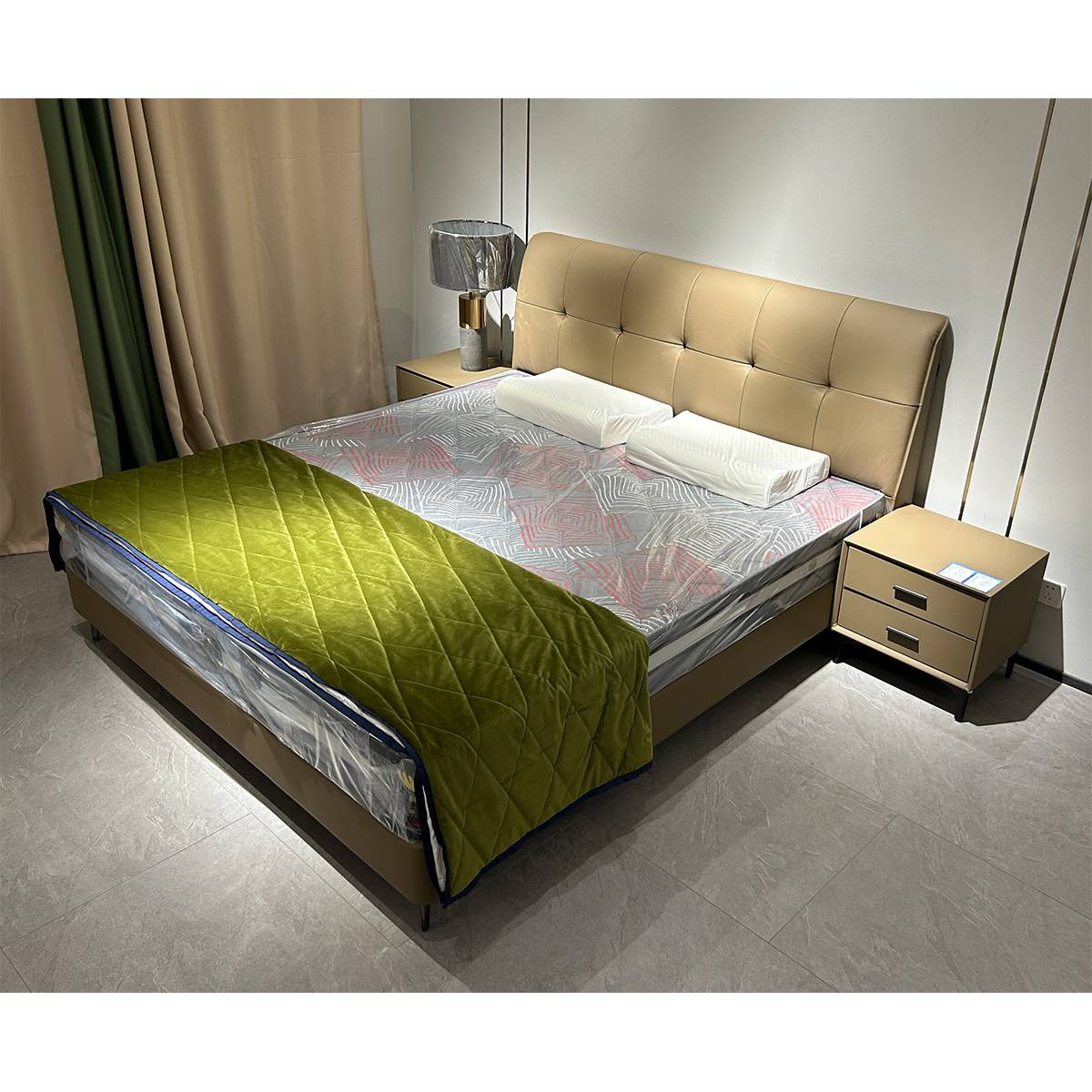 Bedroom setting showing the bed with a green quilt and bedside table