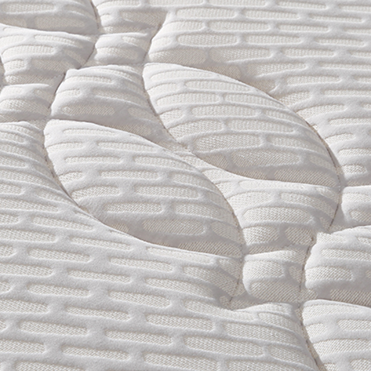 Close-up view of the white mattress surface showing the textured fabric pattern