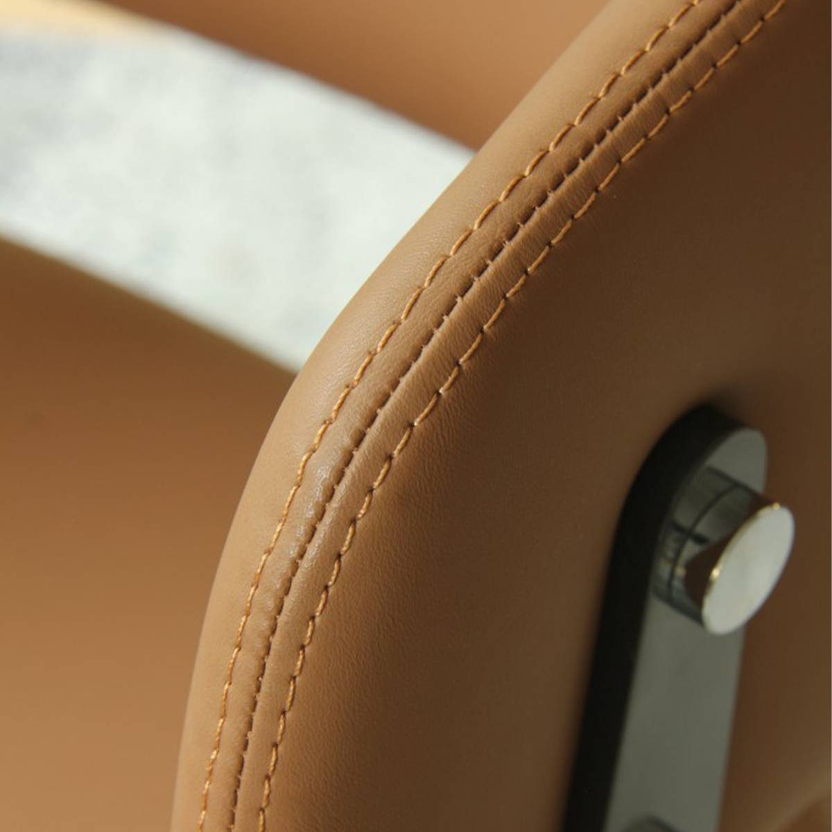 Close-up detail of the orange leather upholstery and stitching