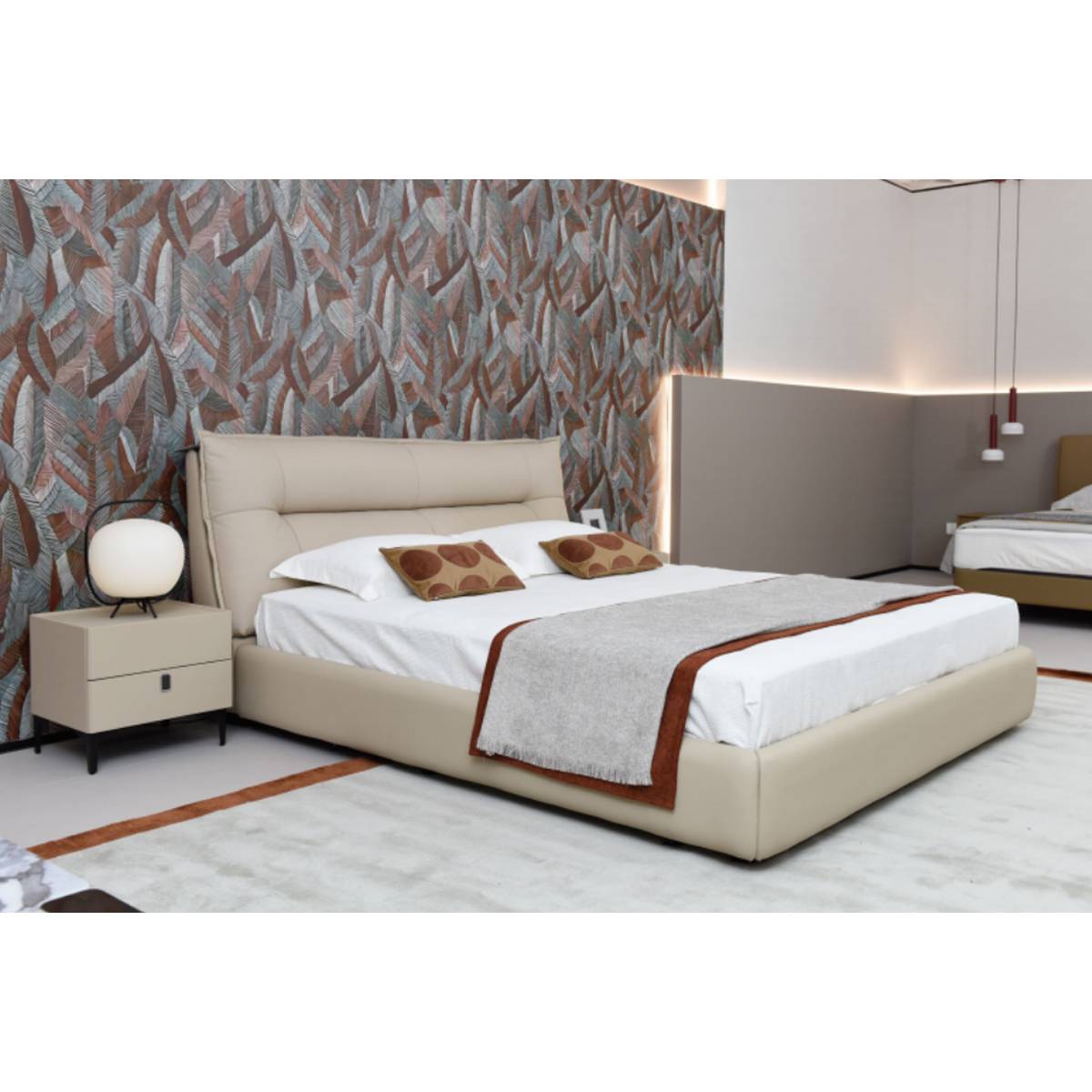 Side view of the beige leather bed with bedside table