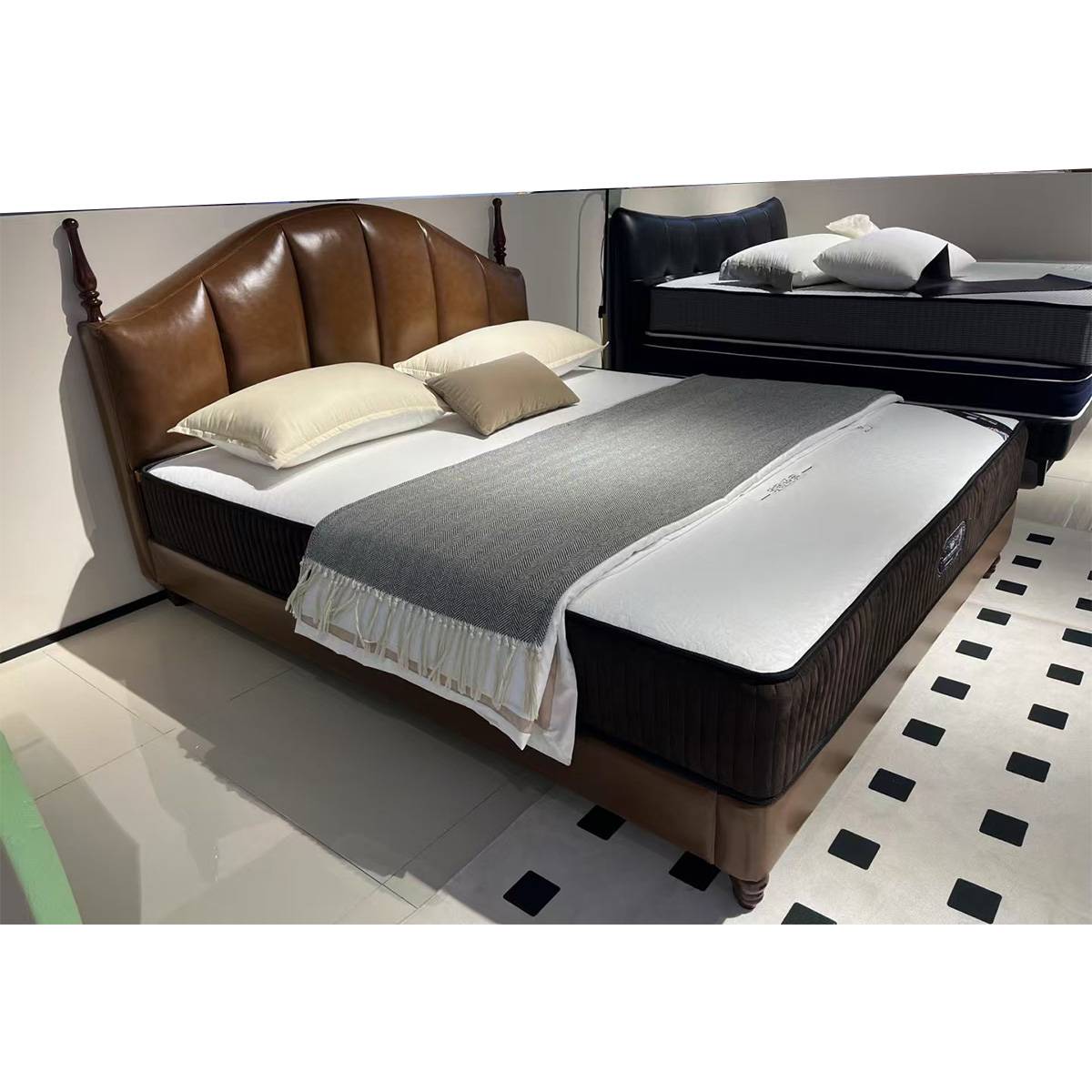 Showroom view of the bed with a mattress and grey throw blanket