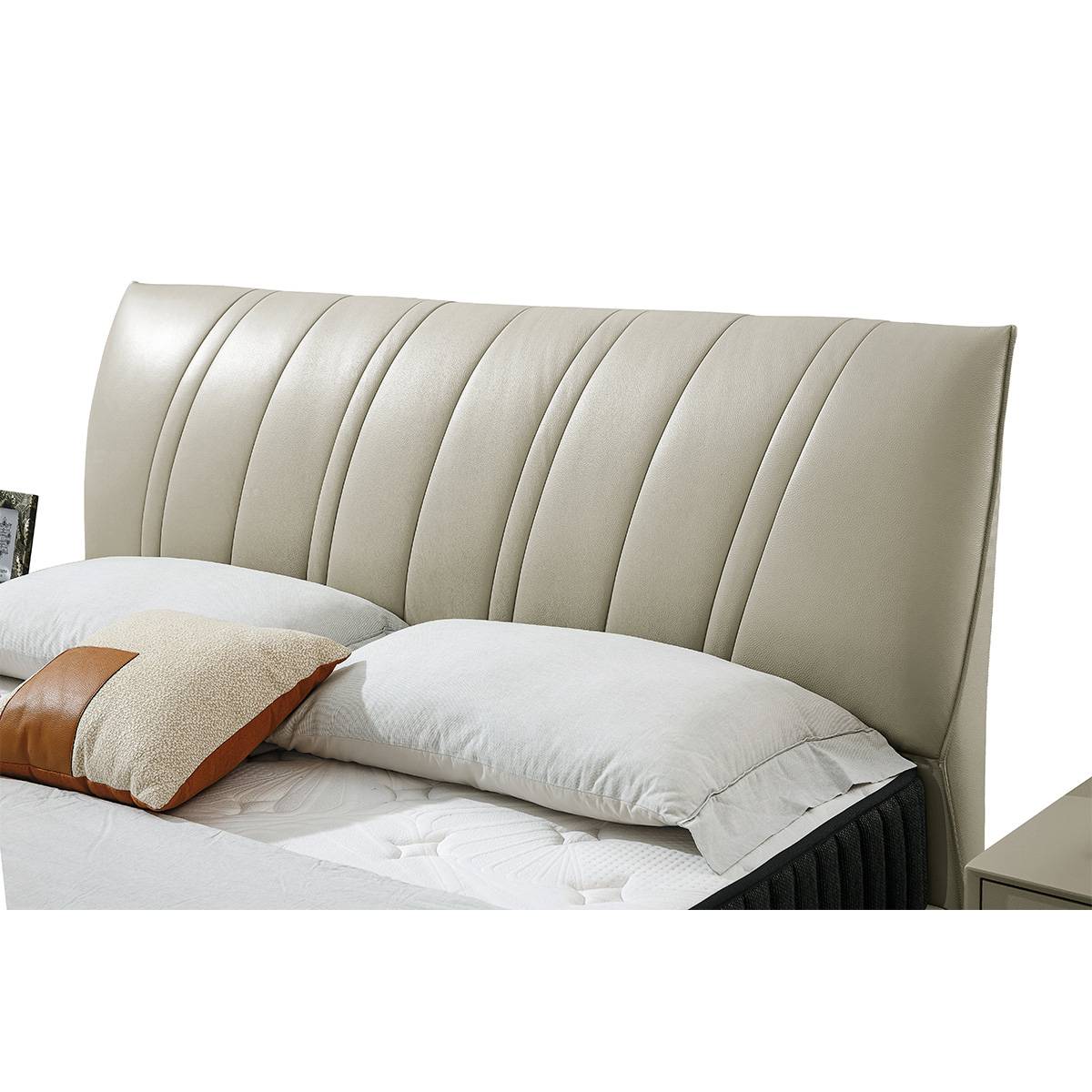 Close-up detail of the tufted leather headboard and pillows