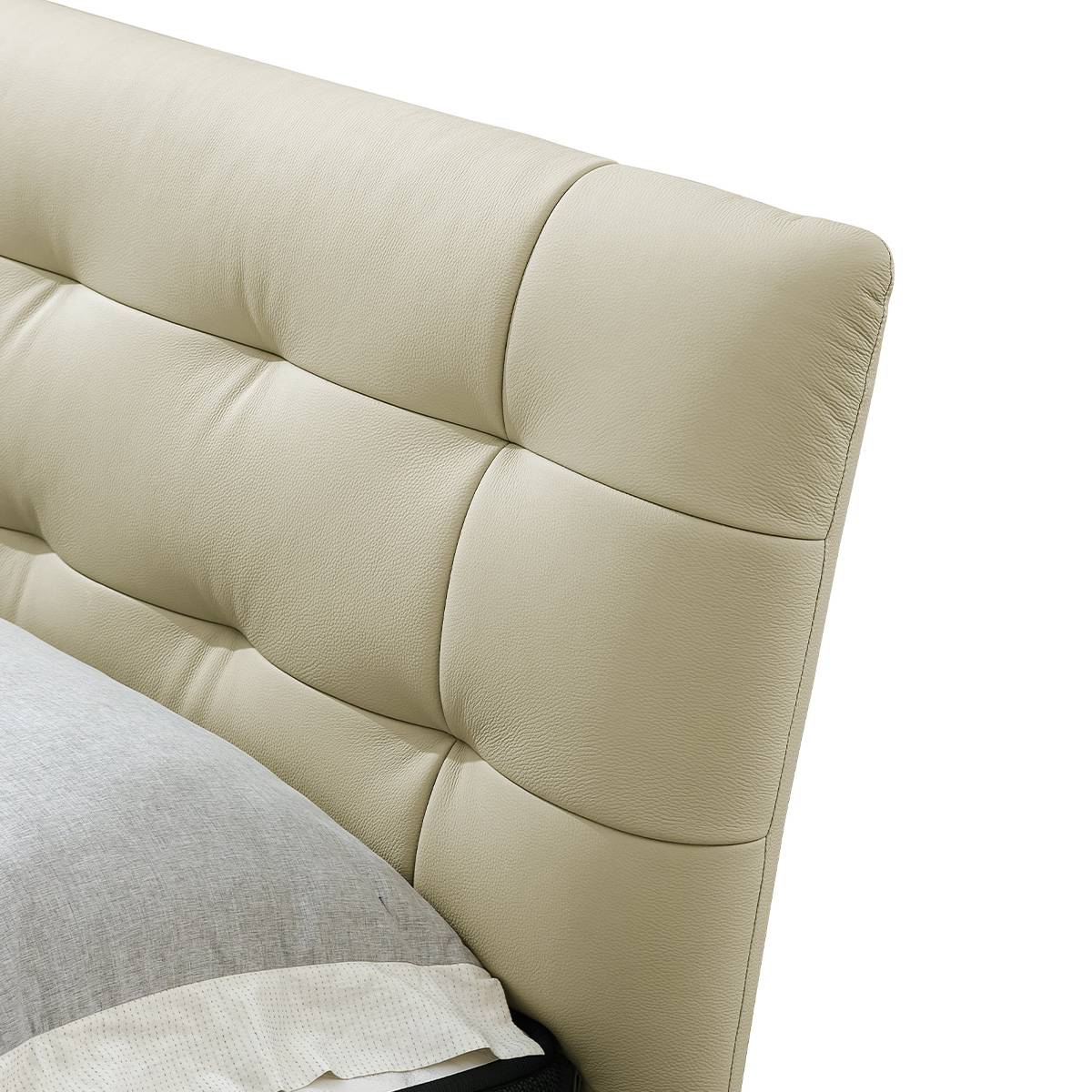 Close-up detail of the tufted leather headboard showing the texture and stitching.