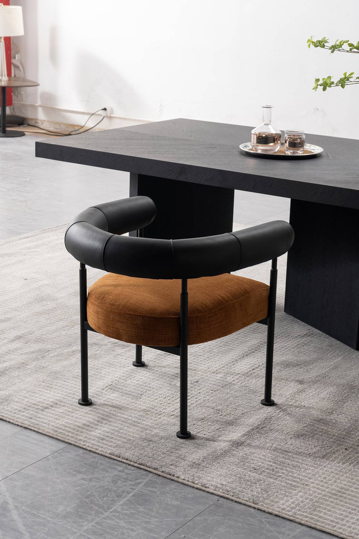 Full view of the lounge chair with black leather armrest and brown seat