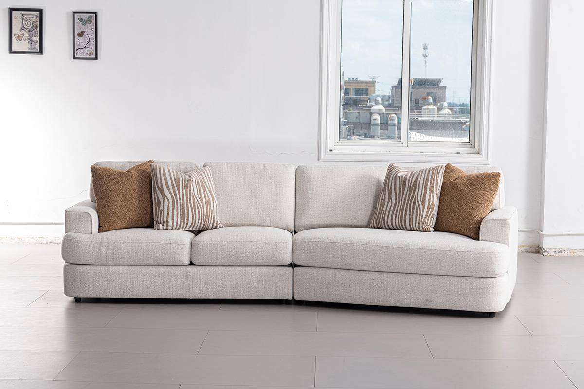 Full frontal view of the light grey fabric sofa with brown and patterned throw pillows in a bright room.