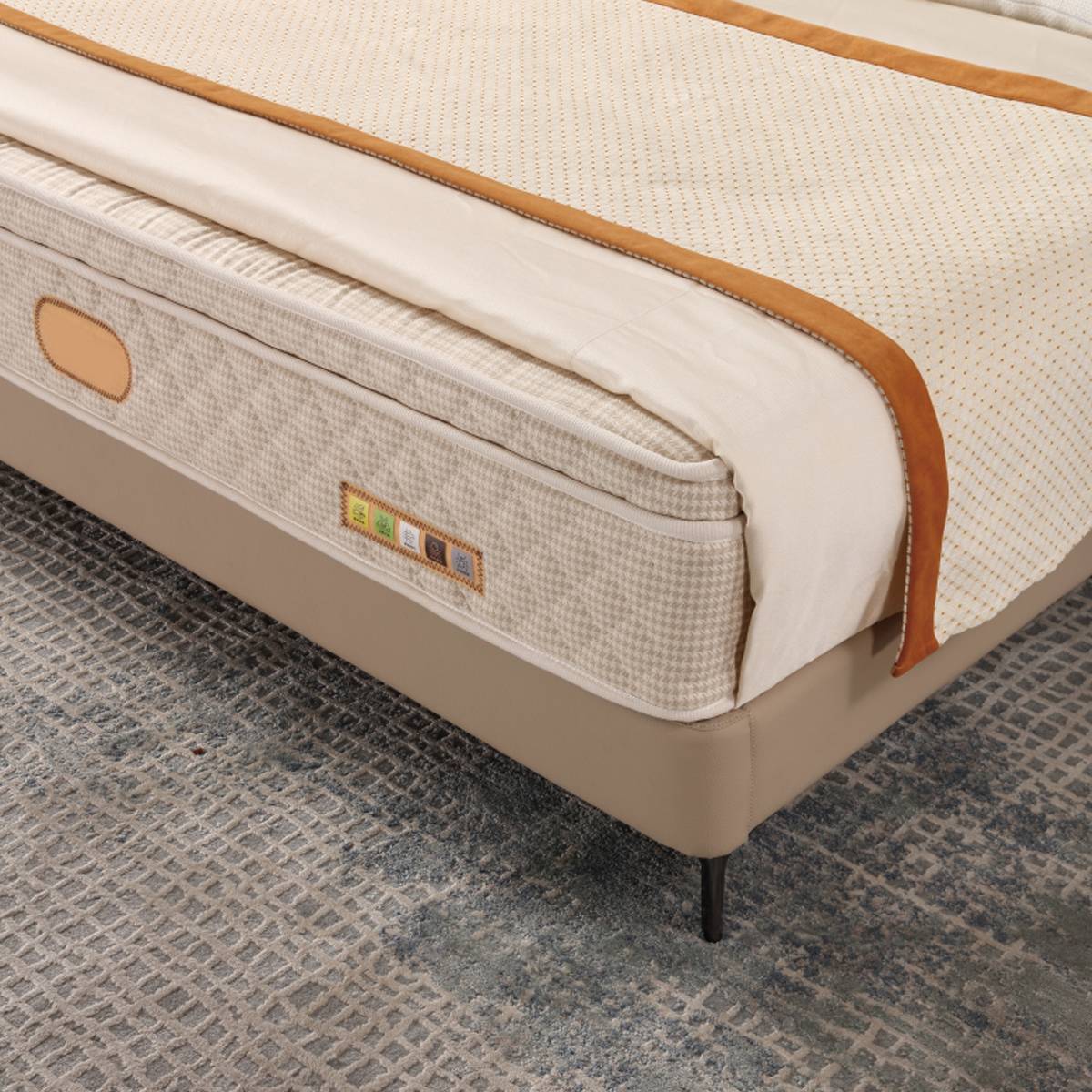Close-up of the beige upholstered bed frame corner showing the mattress and slat structure