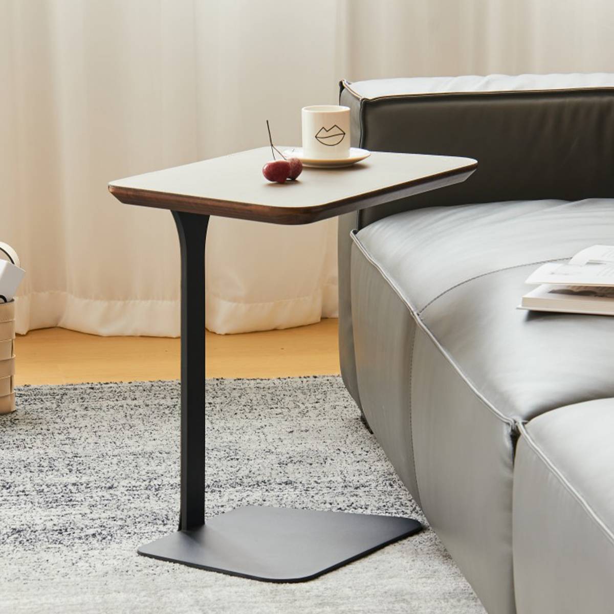 Side profile view of the black leg and base of the side table