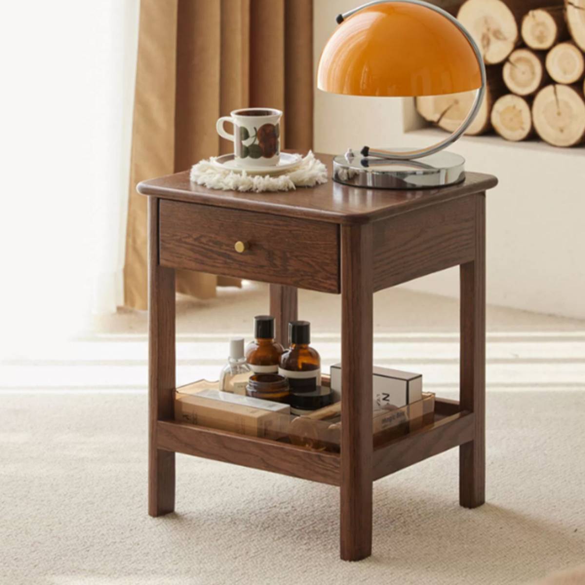 Close-up of a dark wood version of the bedside table with a lamp and coffee cup.