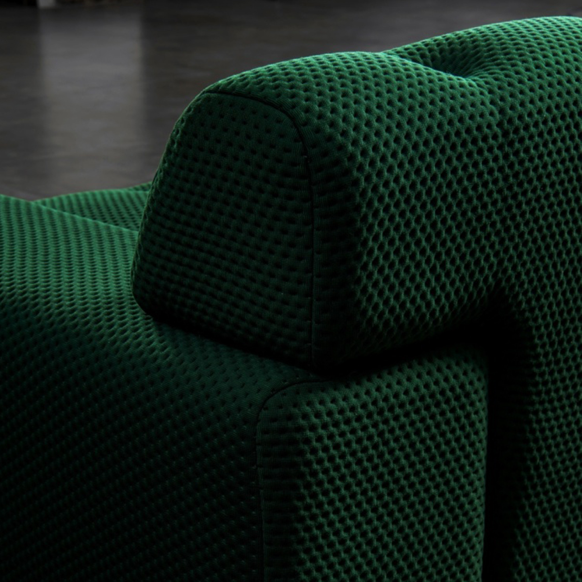 Detail of the sofa armrest and backrest in green fabric