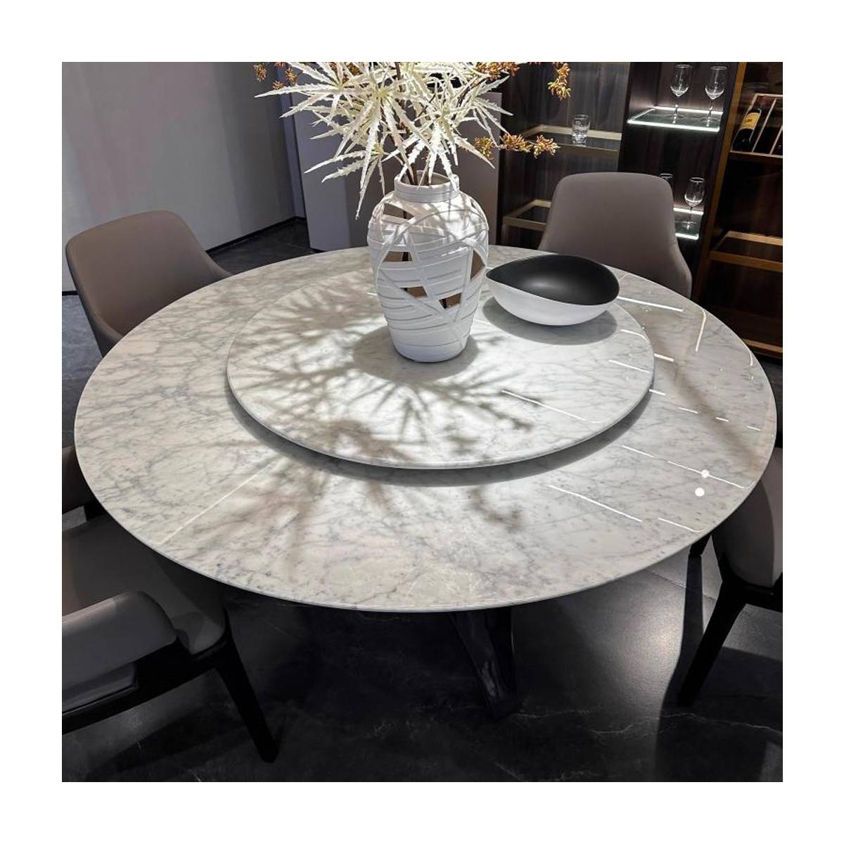 Round marble dining table set with chairs and a decorative vase