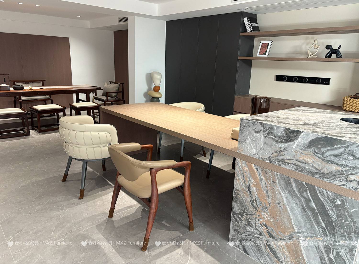 Wide shot of a dining room with a marble island and wooden table, with a tea room in the background