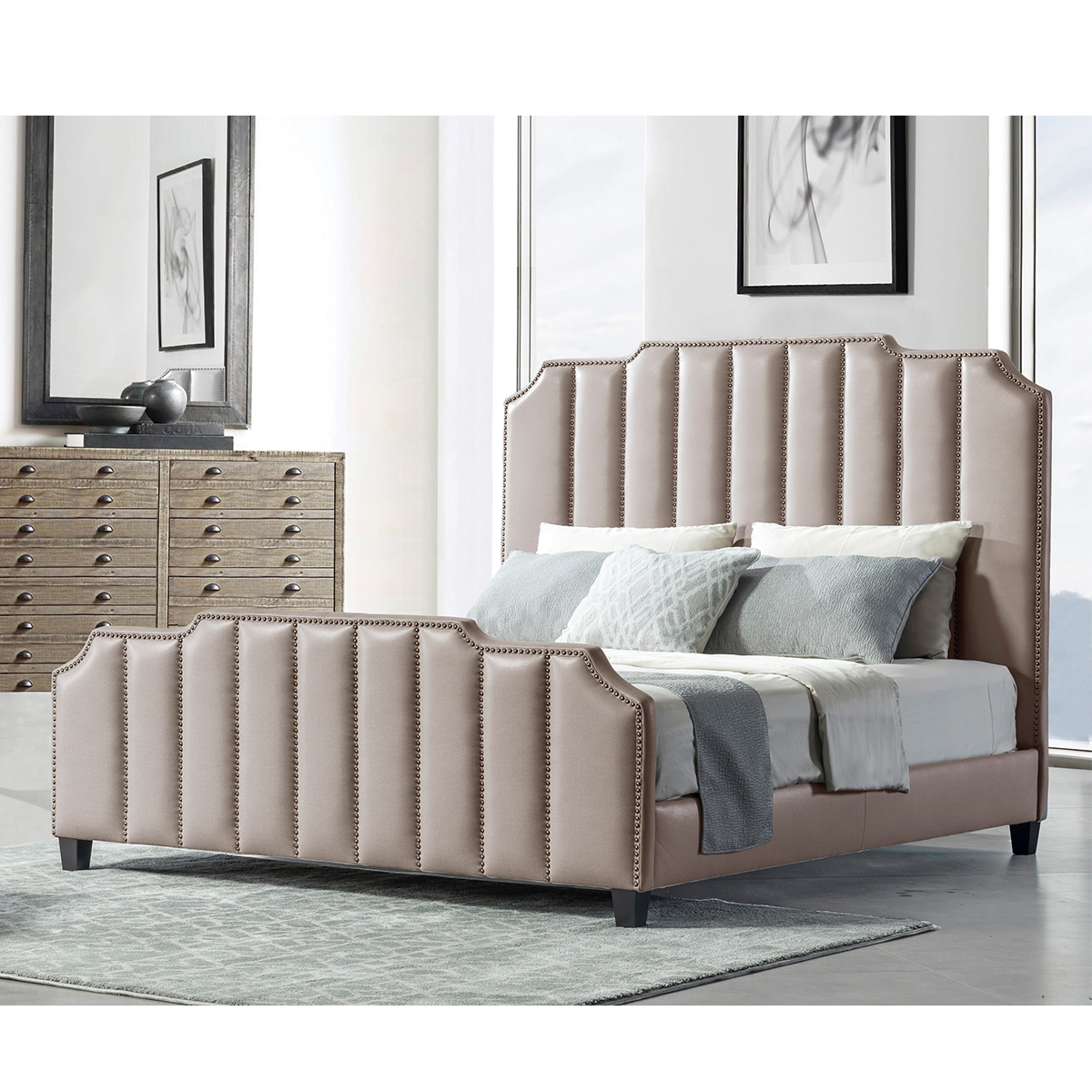 Beige upholstered bed with vertical tufting and nailhead trim in a bedroom setting