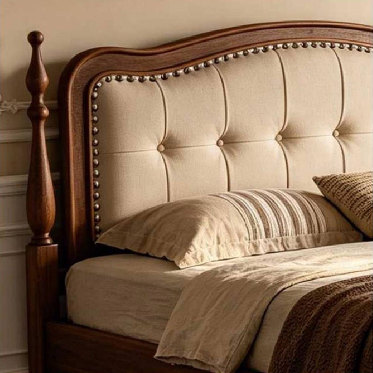 Close-up detail of the tufted headboard and nailhead trim