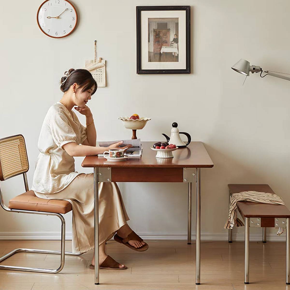 Side view of the dining table with a woman seated, highlighting the stainless steel legs