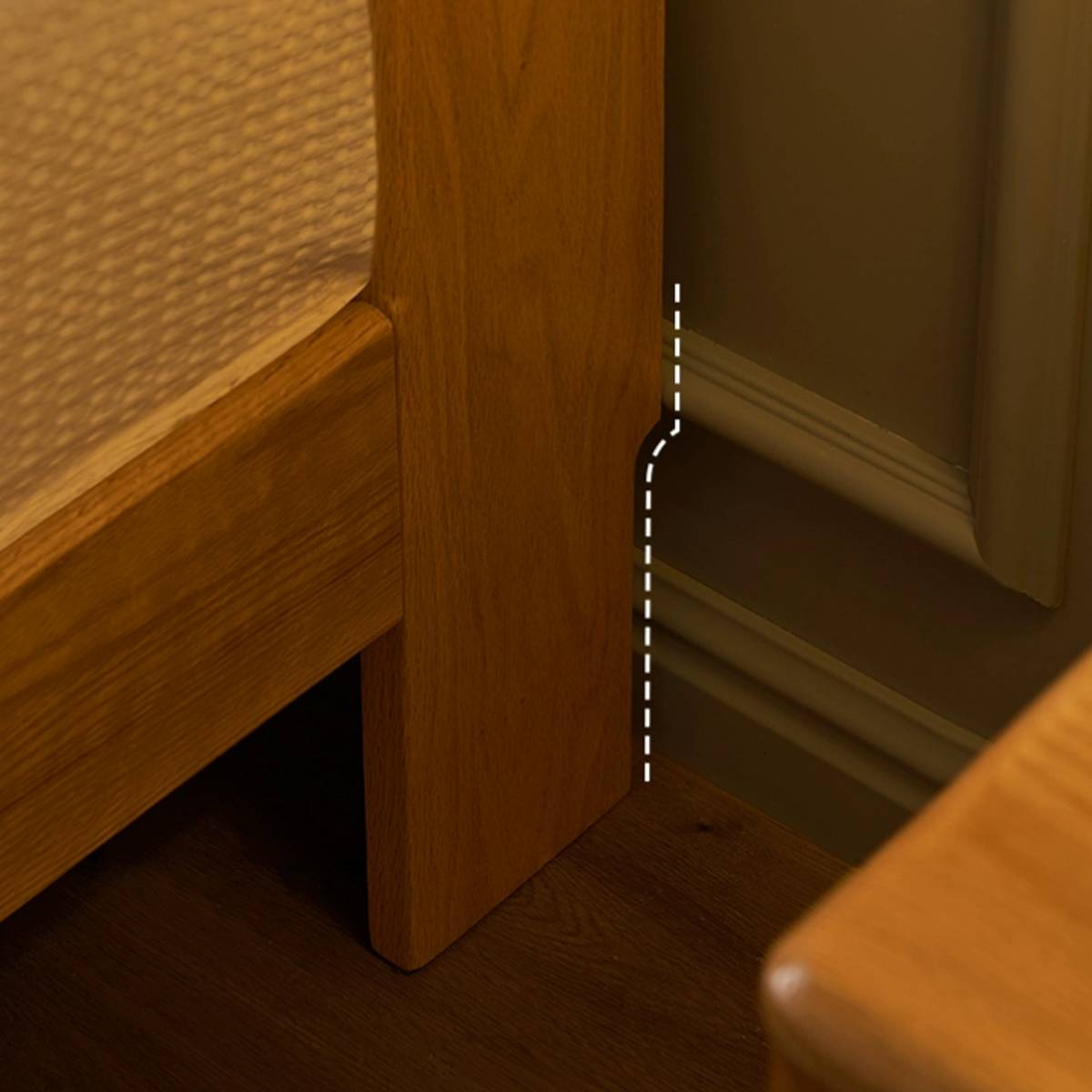 Detail shot of the bed leg showing the cutout design to fit against the wall baseboard.