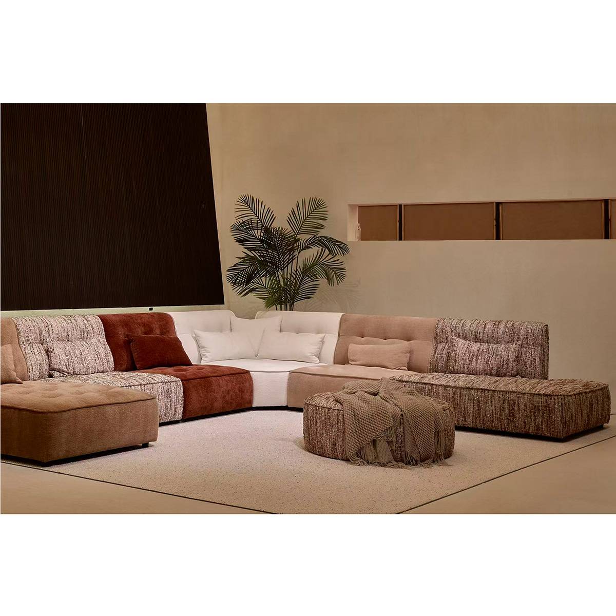 Close-up view of the sofa corner showing tufted brown fabric cushions and pillows