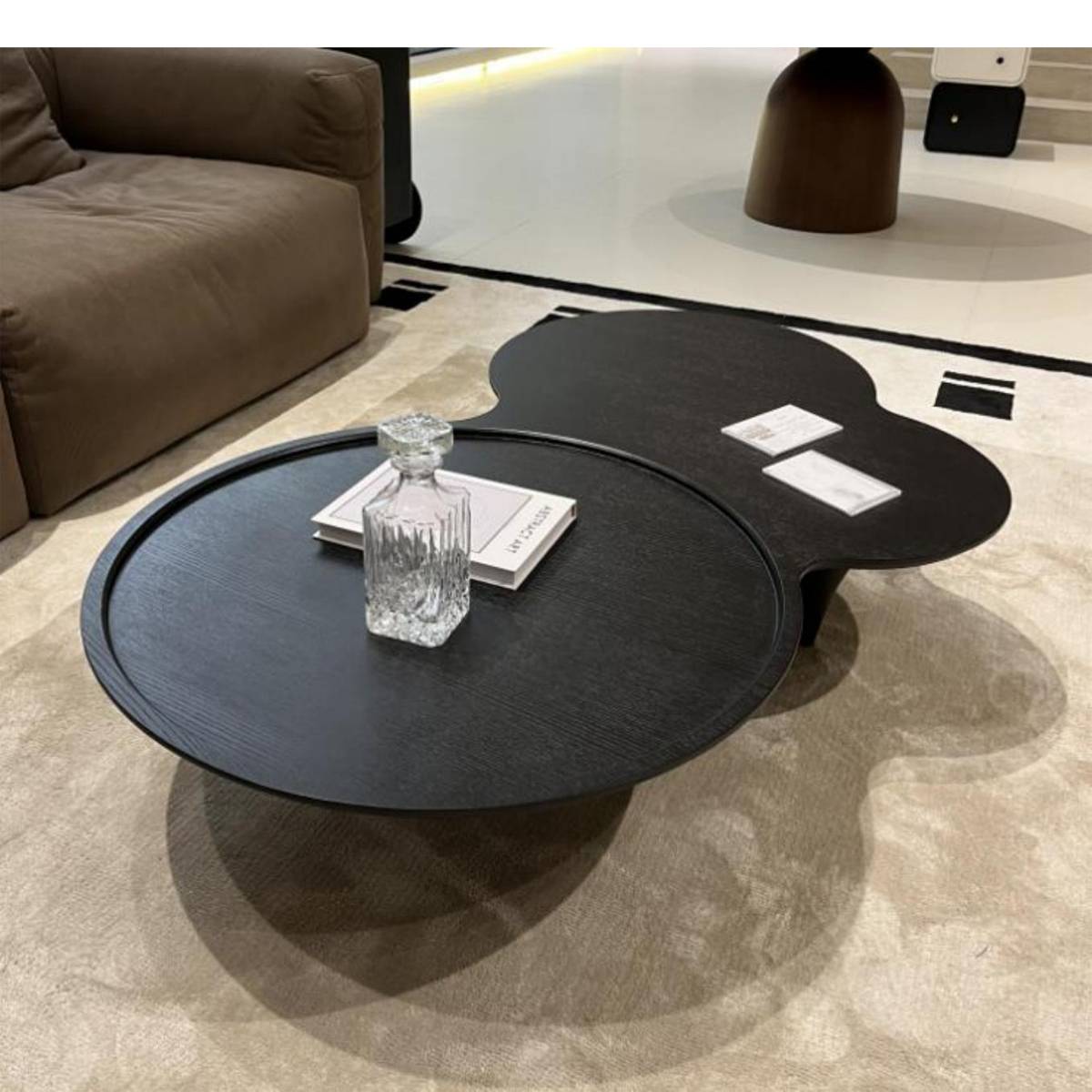 Close-up view of the black coffee table with glass decanter and book