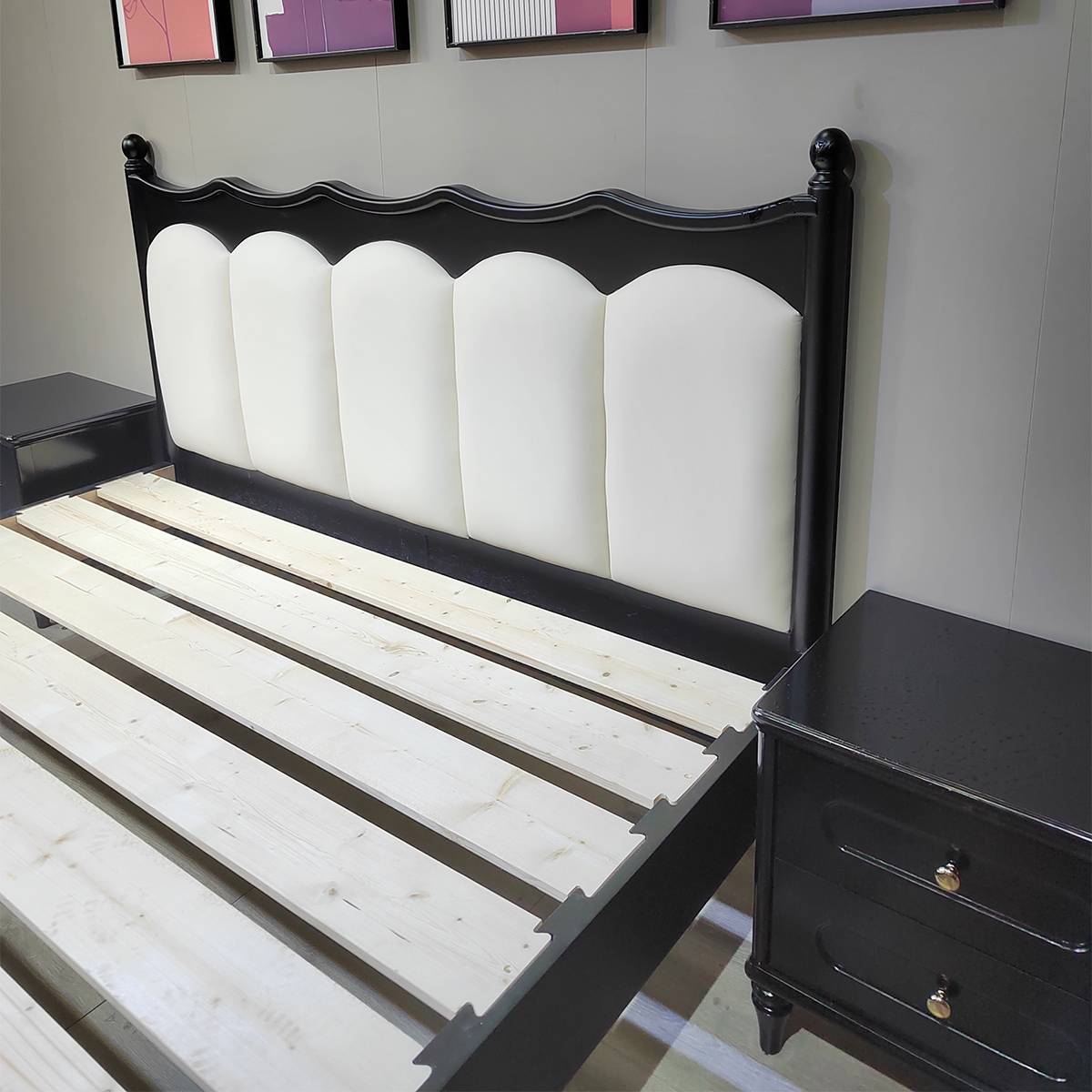 Close up of black bed frame and pine slat base