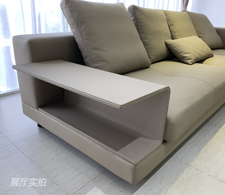 Close-up of the sofa armrest featuring an integrated side table shelf.