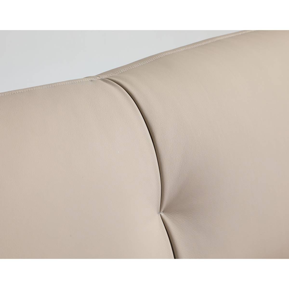 Close-up detail of the beige leather headboard showing stitching and tufting