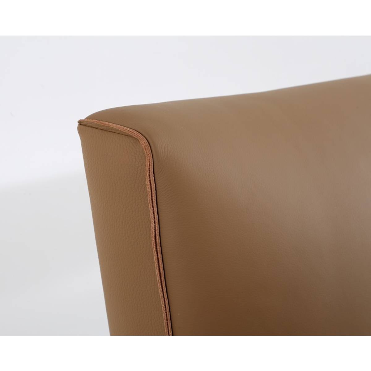 Close-up detail of the brown leather headboard corner showing stitching