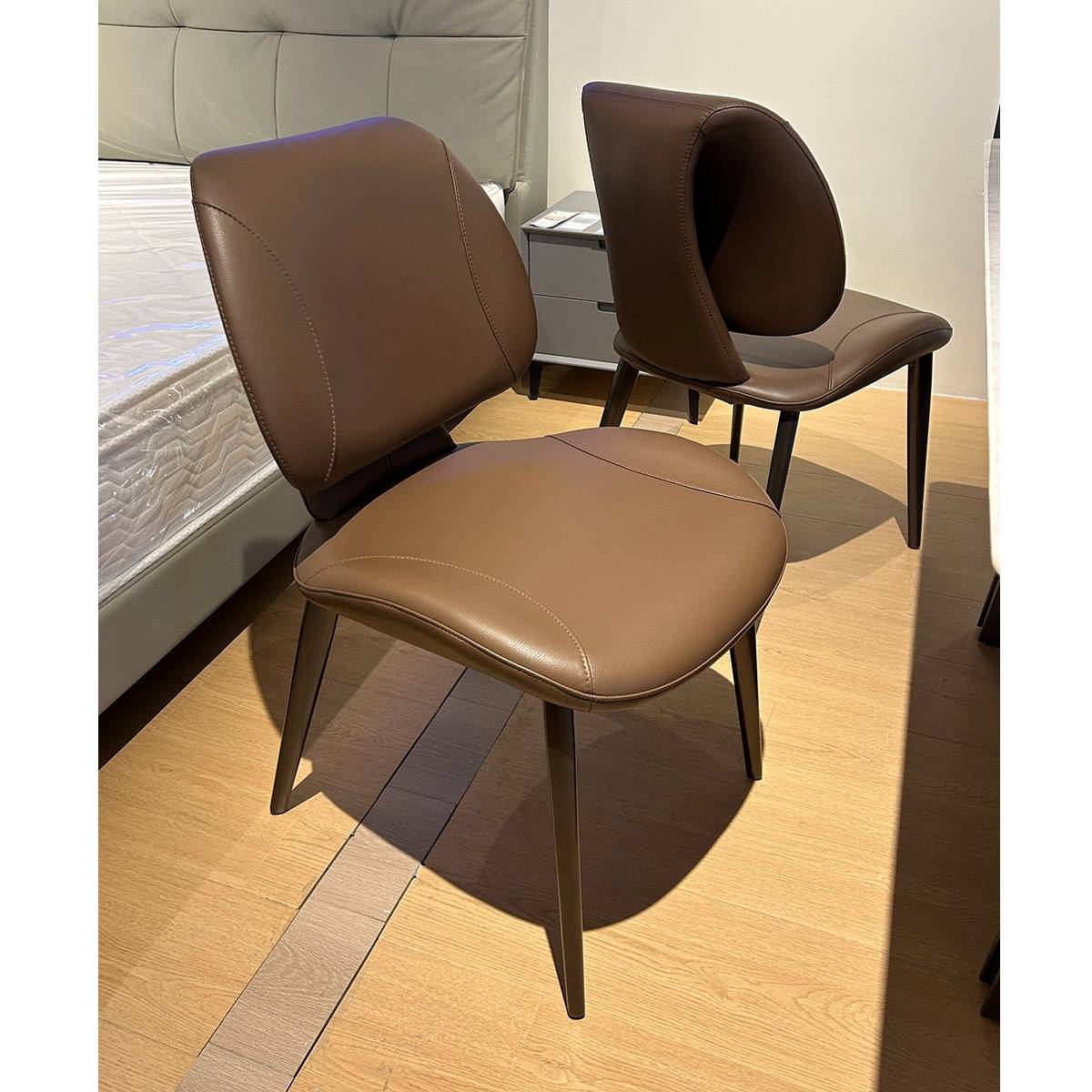 Two khaki dining chairs in a showroom setting